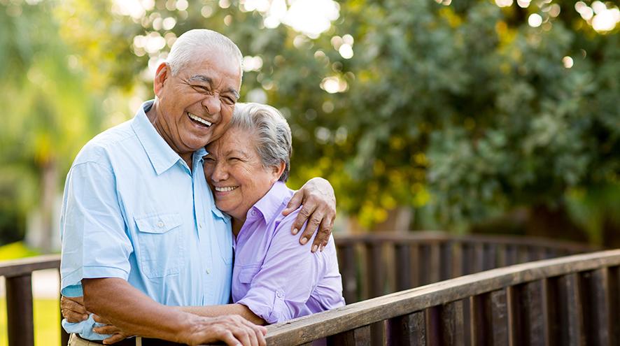 Senior couple laughing together on balcony.