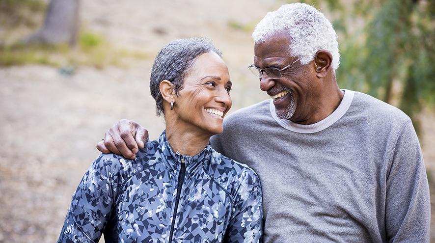 Senior couple smiling while on a walk together.