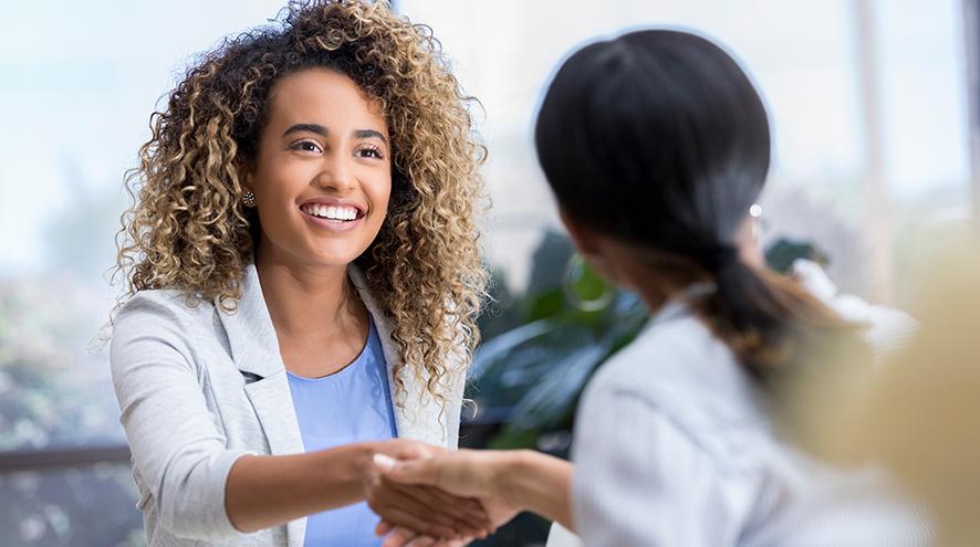 Young woman greeting colleague.