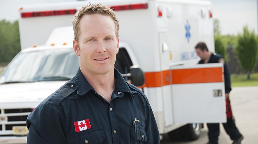 Paramedic standing in front of ambulance.