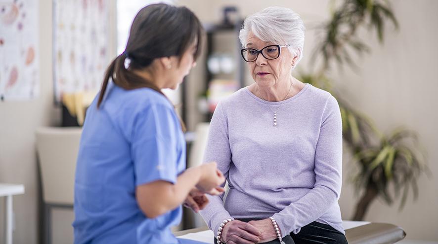 Doctor talking to a senior woman with a sad expression.